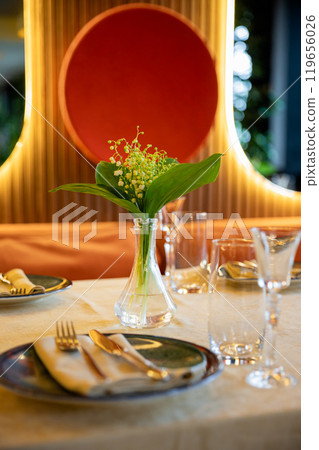 Elegant table setting with sunlight reflections creating a serene and warm dining experience Elegant table setting with sunlight reflections creating a serene and warm dining experience 119656026