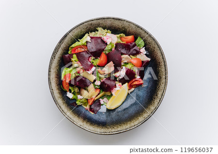 Healthy beetroot salad with fresh tomatoes, feta, and lemon for a nutritious and flavorful meal 119656037