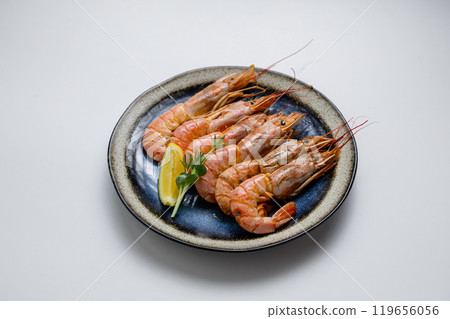 Grilled prawns with herbs and lemon, served on a ceramic plate. Perfect seafood appetizer or meal Grilled prawns with herbs and lemon, served on a ceramic plate. Perfect seafood appetizer or meal 119656056