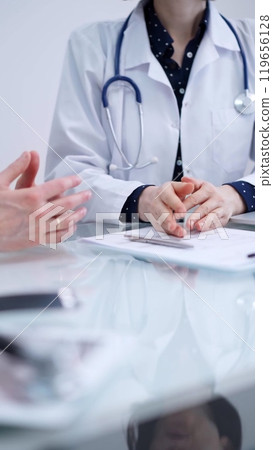 Doctor and patient are sitting and talking at the glass table, Medicine and health care concept Doctor and patient are sitting and talking at the glass table, Medicine and health care concept 119656128