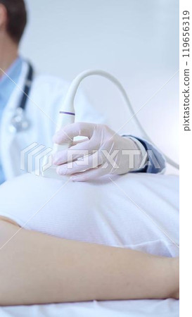 Doctor man is using ultrasound machine to examine internal organs of a patient woman. Female mammary gland health, cancer prevention. Medicine 119656319
