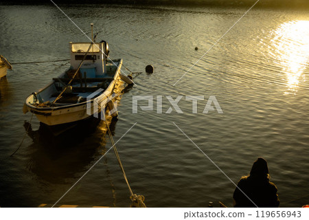 Fishing boat illuminated by the sunset Fishing boat illuminated by the sunset 119656943