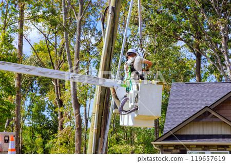 Electrical equipment being serviced at height by technician using bucket truck after hurricane Electrical equipment being serviced at height by technician using bucket truck after hurricane 119657619