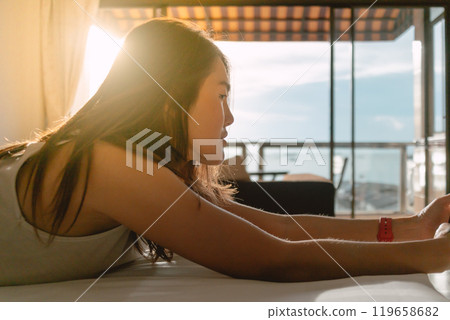 Woman relaxed on the bed with mobile phone, enjoy calmness and warm sun. Woman relaxed on the bed with mobile phone, enjoy calmness and warm sun. 119658682