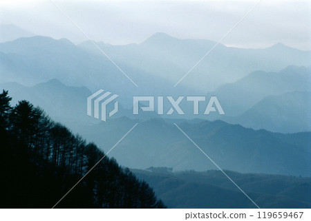 Layers of mountains and the rays of the setting sun 119659467