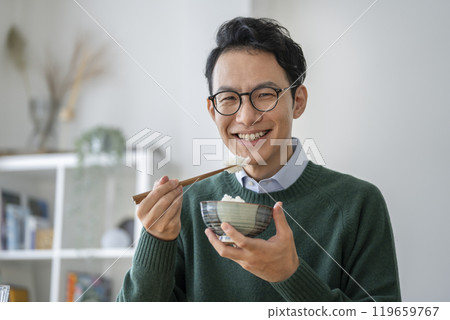 一名 40 歲左右的男子正在吃晚飯,看著鏡頭 一名 40 歲左右的男子正在吃晚飯,看著鏡頭 119659767