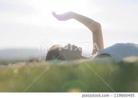 A woman relaxing on the meadow A woman relaxing on the meadow 119660495