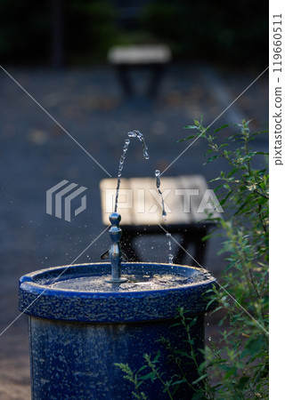 Water from a drinking fountain and benches in the park 119660511