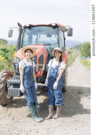 兩個年輕女子站在拖拉機前 119661007