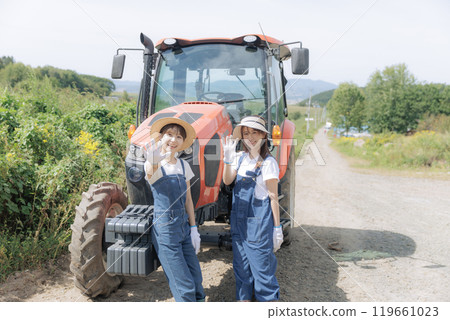 兩個年輕女子站在拖拉機前 兩個年輕女子站在拖拉機前 119661023