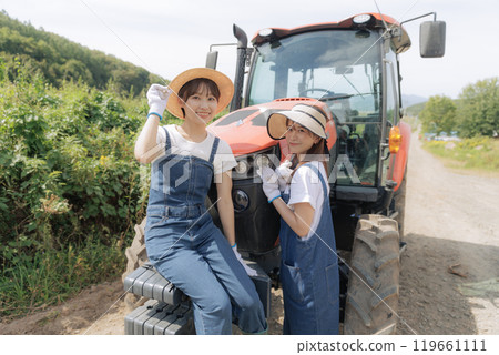 兩個年輕女子站在拖拉機前 119661111