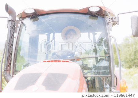 Young woman riding a tractor Young woman riding a tractor 119661447