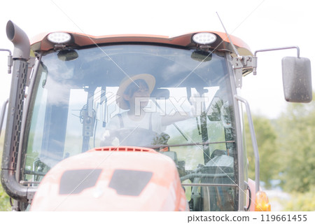 Young woman riding a tractor 119661455