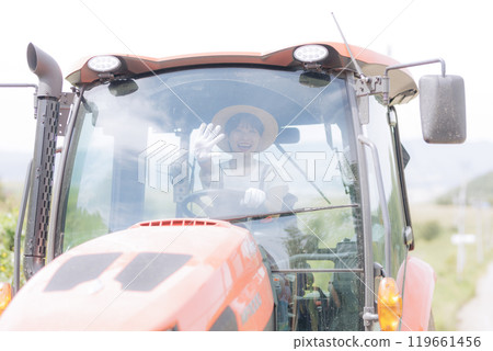 Young woman riding a tractor Young woman riding a tractor 119661456