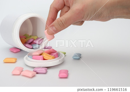 A hand picking up a piece of colorful gum 119661516