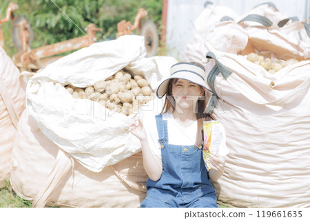 Young woman harvesting potatoes 119661635