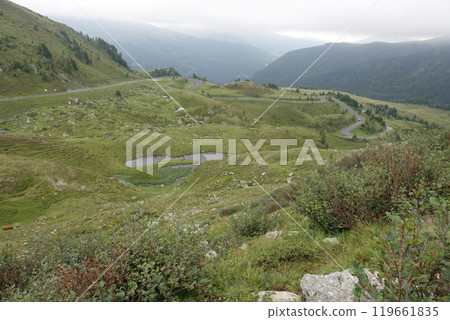 Scenic Mountain Road with Lush Green Hills and Ponds 119661835