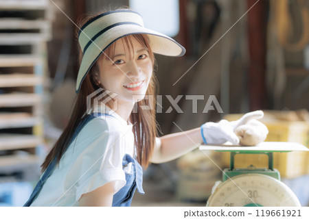 A young woman preparing harvested vegetables for shipment A young woman preparing harvested vegetables for shipment 119661921