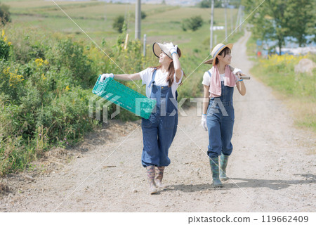 Young women walking with farm tools Young women walking with farm tools 119662409