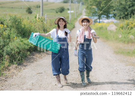 Young women walking with farm tools 119662412