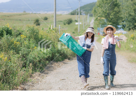 Young women walking with farm tools Young women walking with farm tools 119662413