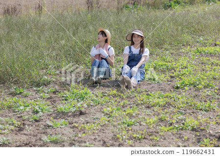 Young women sitting in a field 119662431