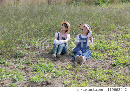 Young women sitting in a field Young women sitting in a field 119662442