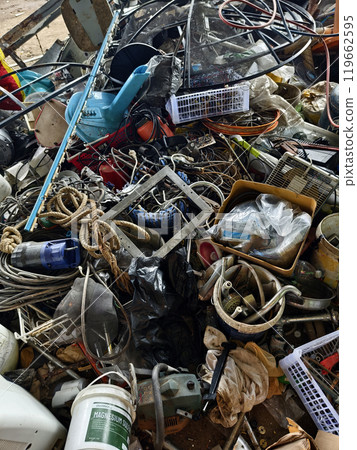 A pile of garbage with a bucket, rope, bottles, and other items at a landfill 119662595