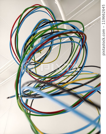 A collection of various wires is hanging down from the ceiling A collection of various wires is hanging down from the ceiling 119662645