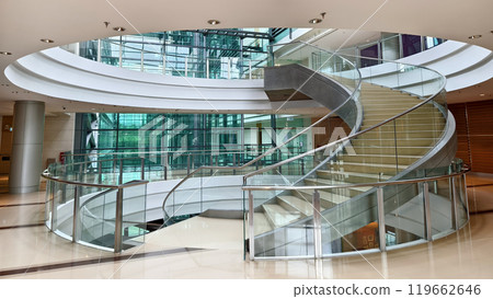 A beautifully designed spiral staircase in a modern building with glass railing A beautifully designed spiral staircase in a modern building with glass railing 119662646