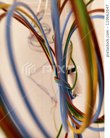 A collection of various wires is hanging down from the ceiling A collection of various wires is hanging down from the ceiling 119662647