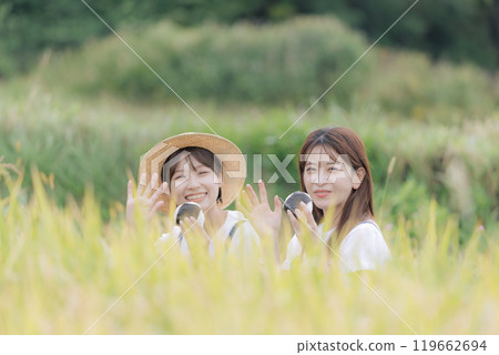 Young women taking a break during the rice harvest Young women taking a break during the rice harvest 119662694