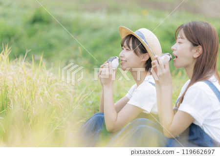 Young women taking a break during the rice harvest Young women taking a break during the rice harvest 119662697