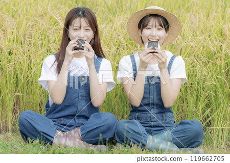 Young women taking a break during the rice harvest Young women taking a break during the rice harvest 119662705