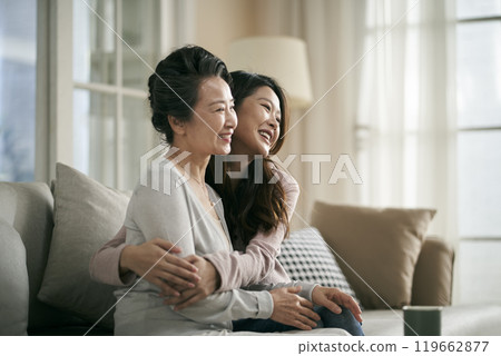 asian adult daughter and senior mother hugging each other at home asian adult daughter and senior mother hugging each other at home 119662877