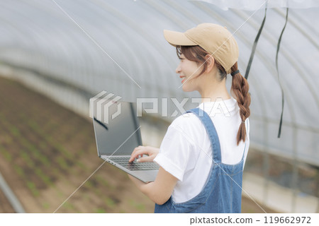 Young woman managing crops using digital device Young woman managing crops using digital device 119662972