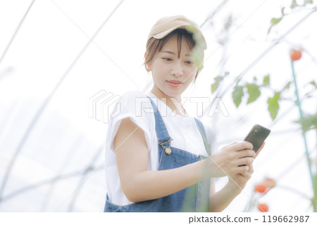 使用數位設備管理農作物的年輕女性 使用數位設備管理農作物的年輕女性 119662987