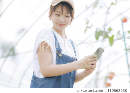 使用數位設備管理農作物的年輕女性 119662988