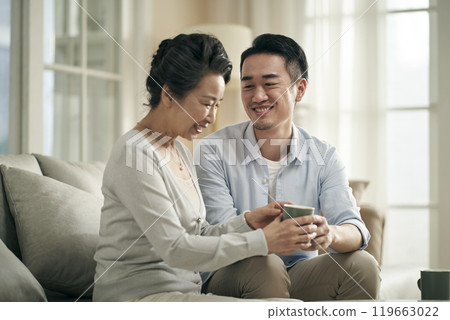 asian adult son and senior mother having a pleasant conversation at home 119663022