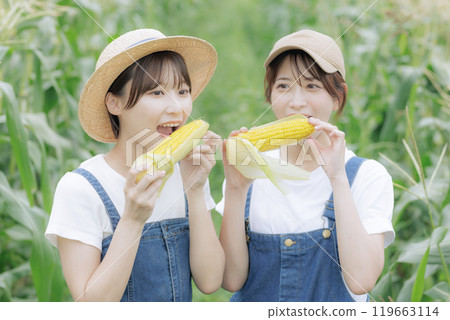 Young women standing with harvested vegetables Young women standing with harvested vegetables 119663114