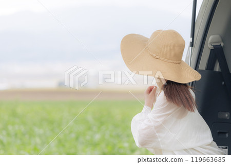 A young woman sitting on a trunk and taking a break 119663685