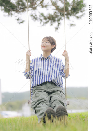 坐在鞦韆上的年輕女子 119663742