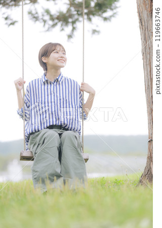 Young woman sitting on a swing Young woman sitting on a swing 119663746