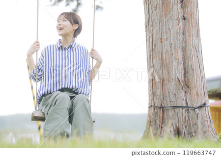 Young woman sitting on a swing 119663747
