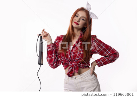 A Stylish Woman Dressed in a Bright Red Checkered Shirt While Using Her Hair Iron A Stylish Woman Dressed in a Bright Red Checkered Shirt While Using Her Hair Iron 119663801