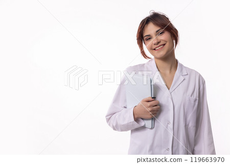 A Smiling Woman Wearing a Lab Coat While Holding a Notepad with a Cheerful Expression 119663970