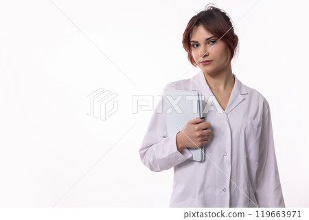 A Young Professional Dressed in a Lab Coat Holding a Notebook as a Symbol of Knowledge and Expertise 119663971