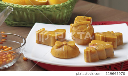Frozen sea buckthorn and orange tea in Christmas molds on white plate in kitchen. Healthy eating and seasons.  119663978