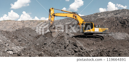 Large quarry dump excavator. Big yellow mining excavator at work site. Loading coal into body truck. Mining digger, mining machinery to loading rock. Production useful minerals Large quarry dump excavator. Big yellow mining excavator at work site. Loading coal into body truck. Mining digger, mining machinery to loading rock. Production useful minerals 119664891