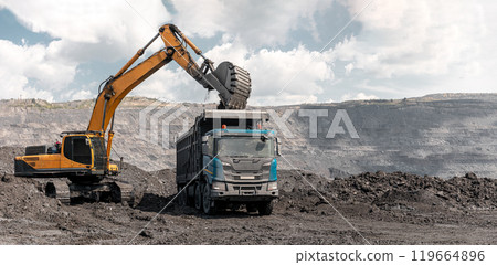 Large quarry dump truck and excavator. Big mining truck work coal deposit. Loading coal into body truck. Production useful minerals. Mining mining machinery to transport coal from open-pit production Large quarry dump truck and excavator. Big mining truck work coal deposit. Loading coal into body truck. Production useful minerals. Mining mining machinery to transport coal from open-pit production 119664896